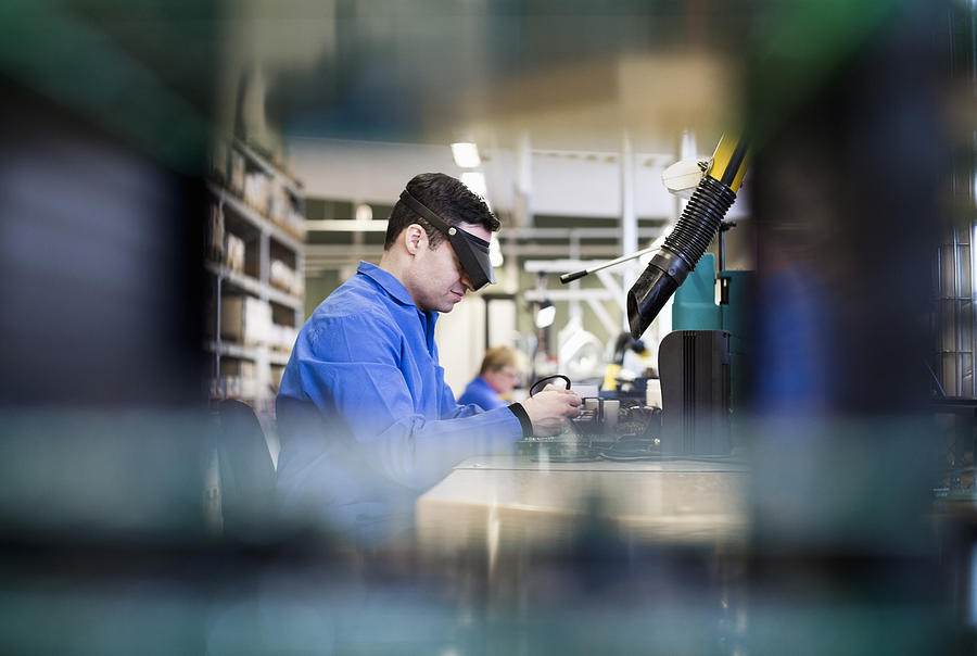 Side view of male technician wearing protective eyewear working in industry Photograph by Maskot