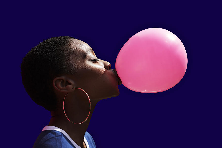 Side view of young woman blowing balloon Photograph by Klaus Vedfelt