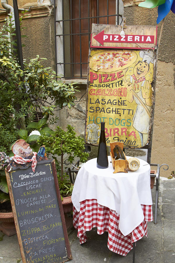 Sign and table outside pizzeria Photograph by Rolf Bruderer