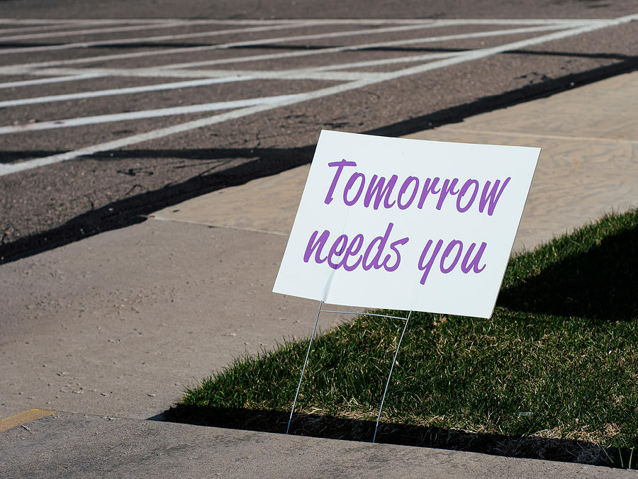 Sign that reads Tomorrow needs you placed by a sidewalk. Photograph by Harpazo_hope