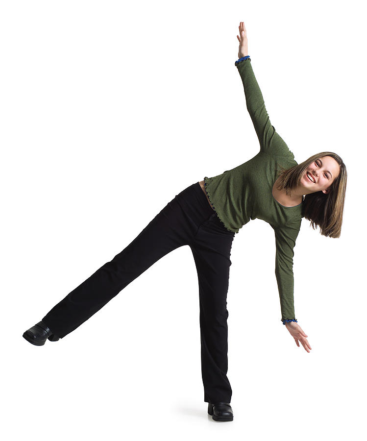 Silhouette Of A Caucasian Teenage Girl In Black Pants And A Green Shirt As She Balances On One Leg Photograph by Photodisc