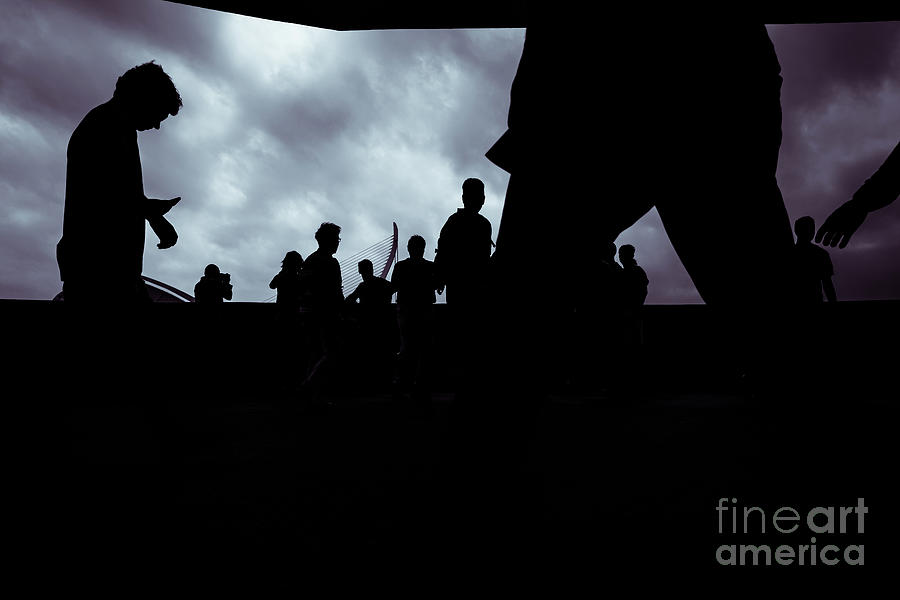 Silhouette of a group of unrecognizable people using their smart Photograph by Joaquin Corbalan