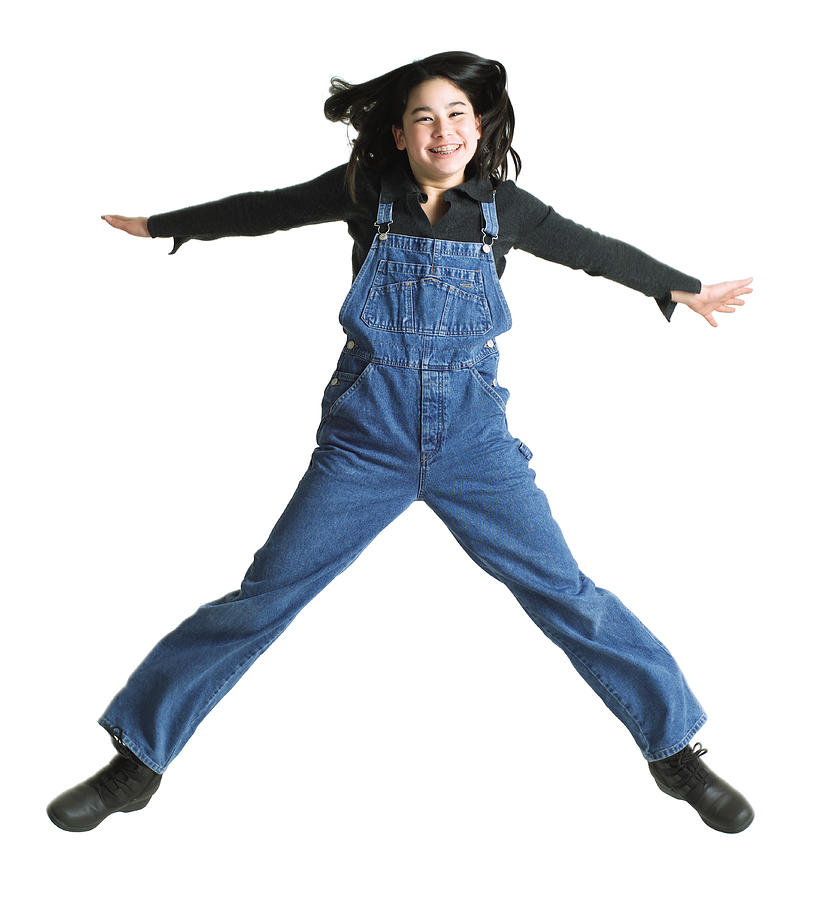 Silhouette Of An Asian Teenage Girl In Denim Overalls As She Jumps Up Into The Air Photograph by Photodisc
