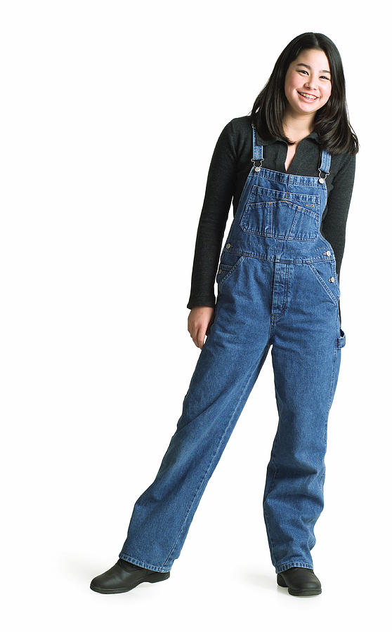 Silhouette Of An Asian Teenage Girl In Denim Overalls As She Smiles At The Camera Photograph by Photodisc