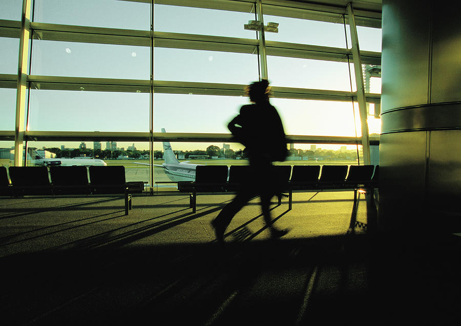 Silhouette of businessperson hurrying through airport terminal. Photograph by Gerard Launet