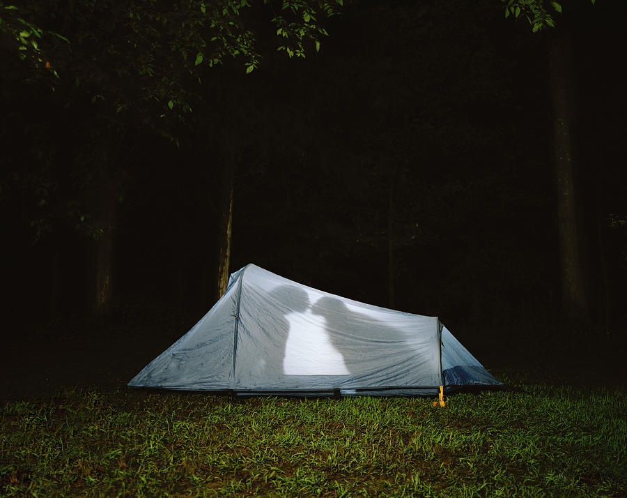 Silhouette of couple kissing in tent, night Photograph by Shannon Fagan