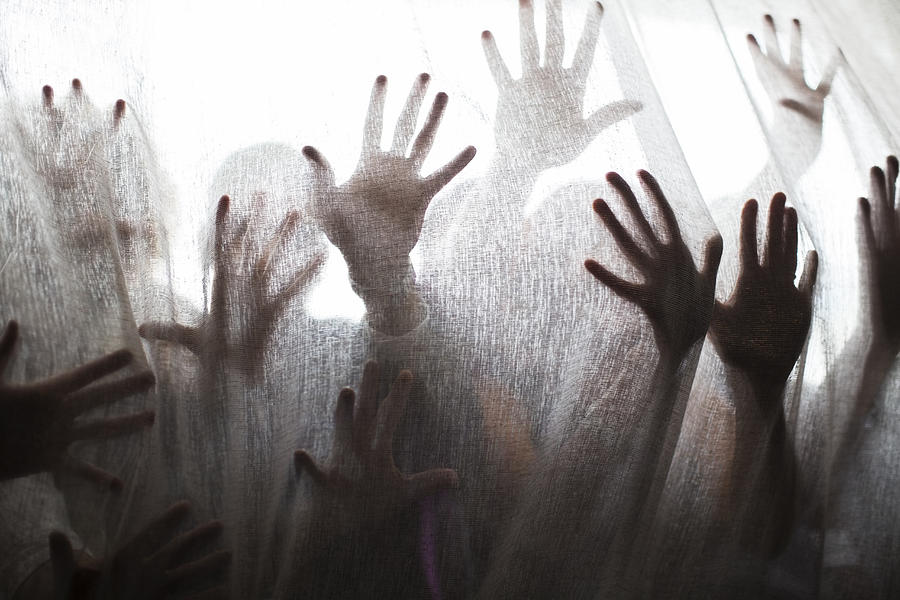 Silhouette of people raising hands behind transparent curtain Photograph by Sam Edwards