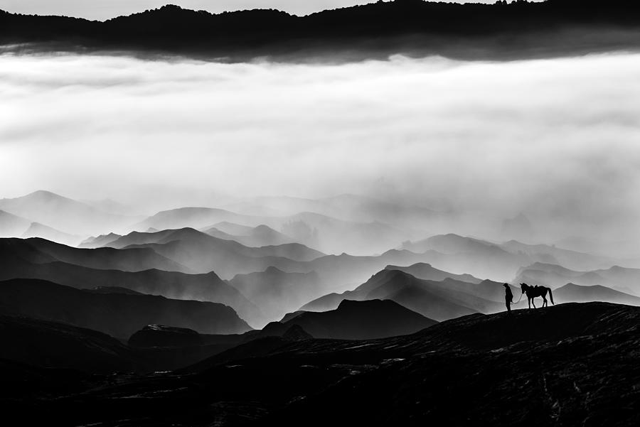 Silhouette of unidentified local people or Bromo Horseman at mountainside of Mount Bromo. Photograph by Shaifulzamri