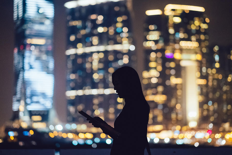 Silhouette of woman with digital tablet in city Photograph by D3sign