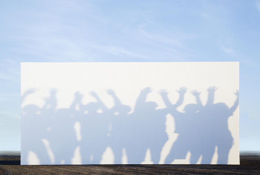 Silhouette shadows of people on a billboard Photograph by OJO Images