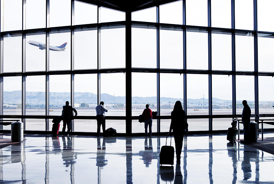 Silhouettes of passengers waiting at an airport Photograph by Caroline Purser