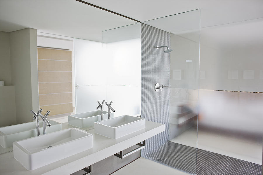 Sinks and shower in bathroom of modern home Photograph by Paul Bradbury