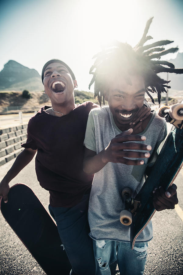 Skateboarders Laugh Together, Outside, With Skateboards in Hand Photograph by Wundervisuals