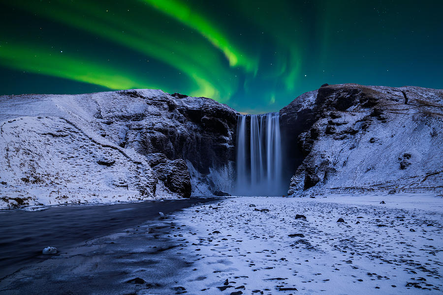 Skogafoss waterfall in the winter at night under the northern lights. Iceland Photograph by Anton Petrus