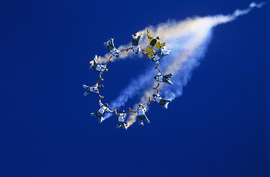 Skydivers forming ring against blue sky Photograph by Moodboard