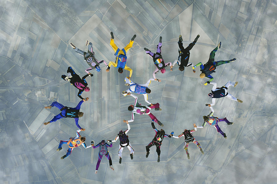Skydivers forming two circles over earth, view from above Photograph by Moodboard