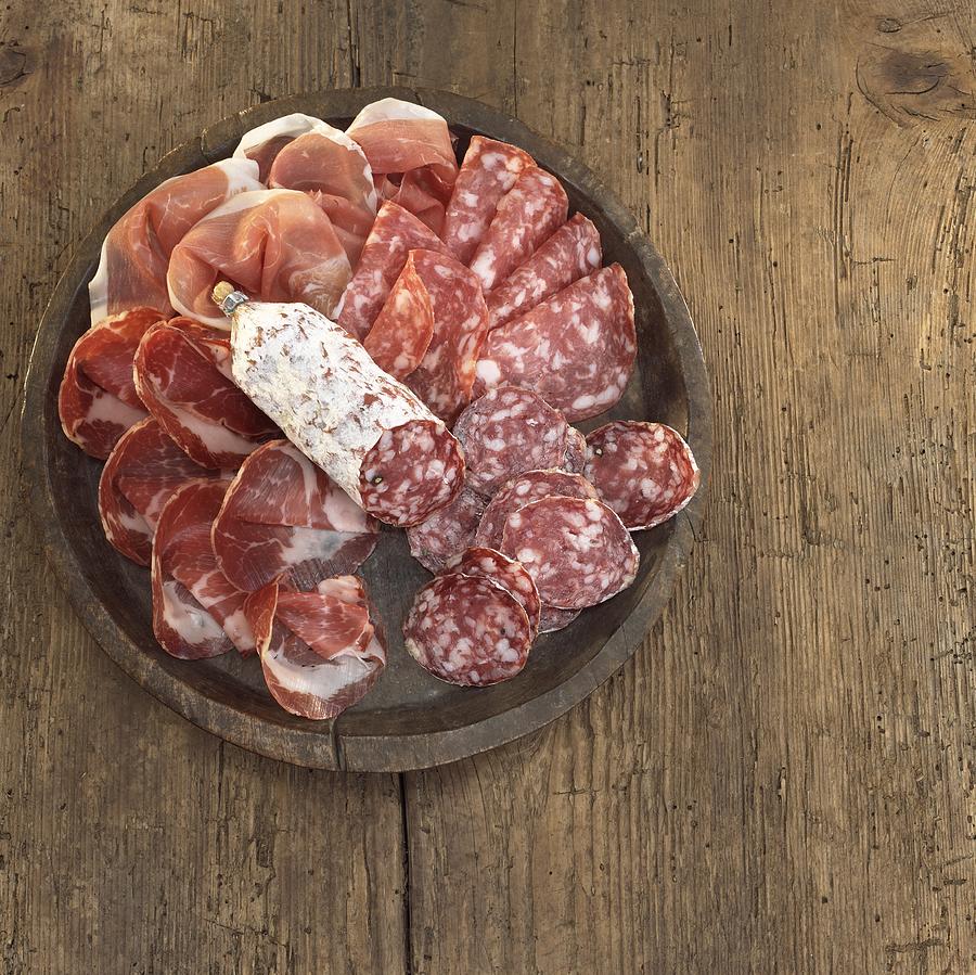 Sliced salami and ham on plate, elevated view Photograph by Westend61