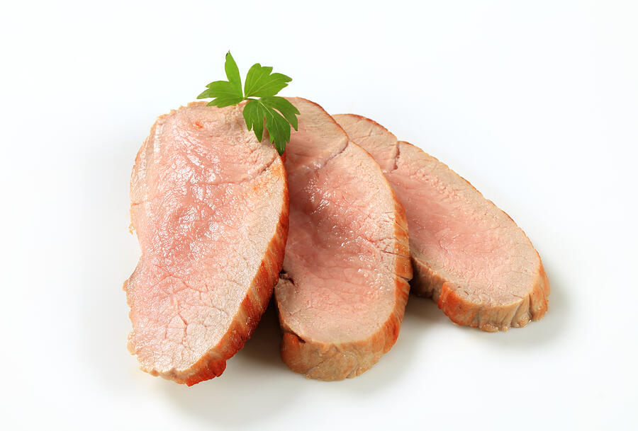 Slices of roasted pork placed on a white background Photograph by Milanfoto