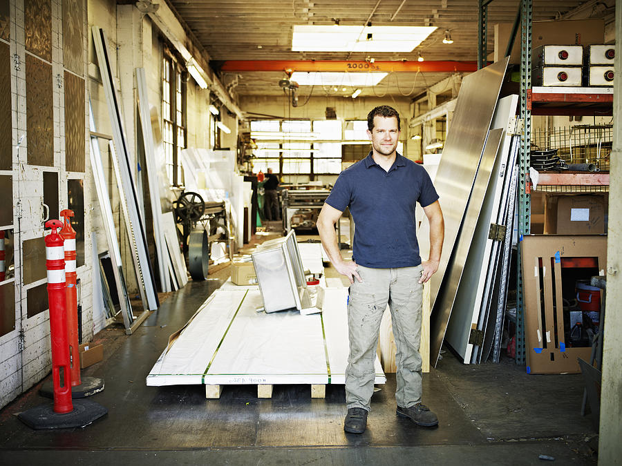Small business owner in entrance of metal shop Photograph by Thomas Barwick