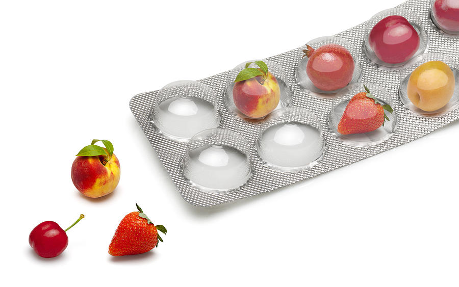 Small fruits in a pill blister packs Photograph by Syolacan