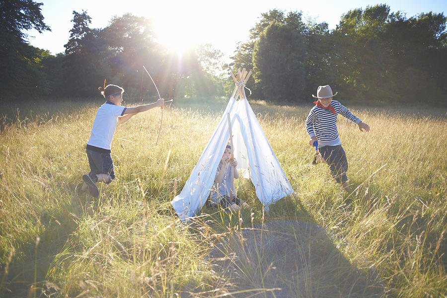 Small group of young boys playing around teepee Photograph by Peter Muller