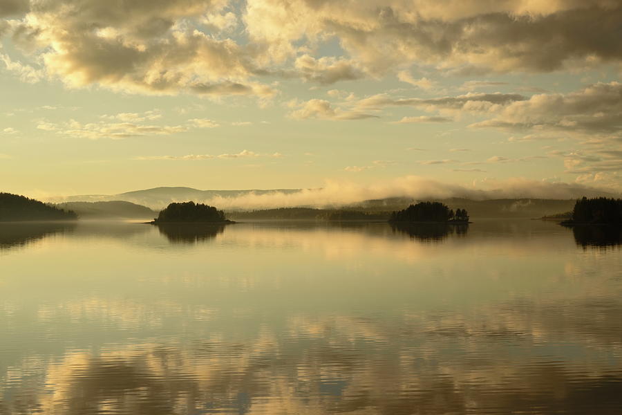 Small islands are reflected in the glassy water of a lake at sun Photograph by Ulrich Kunst And Bettina Scheidulin