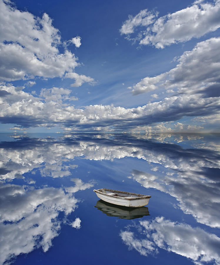 Small rowing boat with reflection of clouds in sea Photograph by Adam Jones