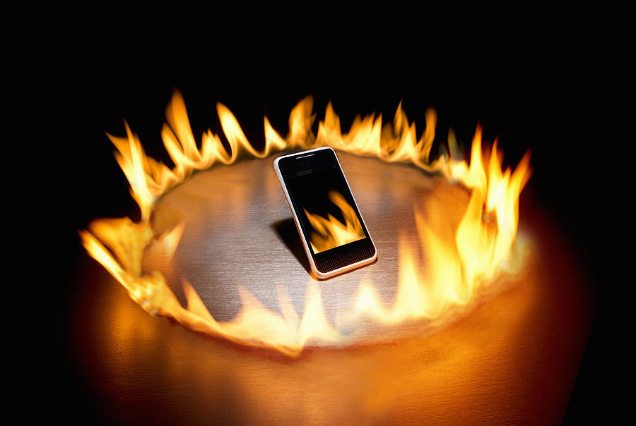 Smart phone in ring of fire Photograph by PM Images