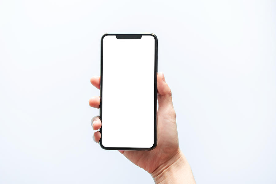 Smartphone mockup. Hand holding black phone white screen. Isolated on white background. Mobile phone frameless design concept. Photograph by Oatawa