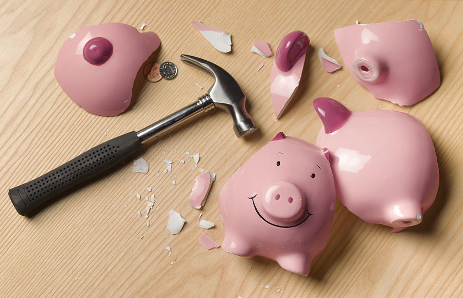 Smashed piggy bank with change Photograph by Peter Dazeley
