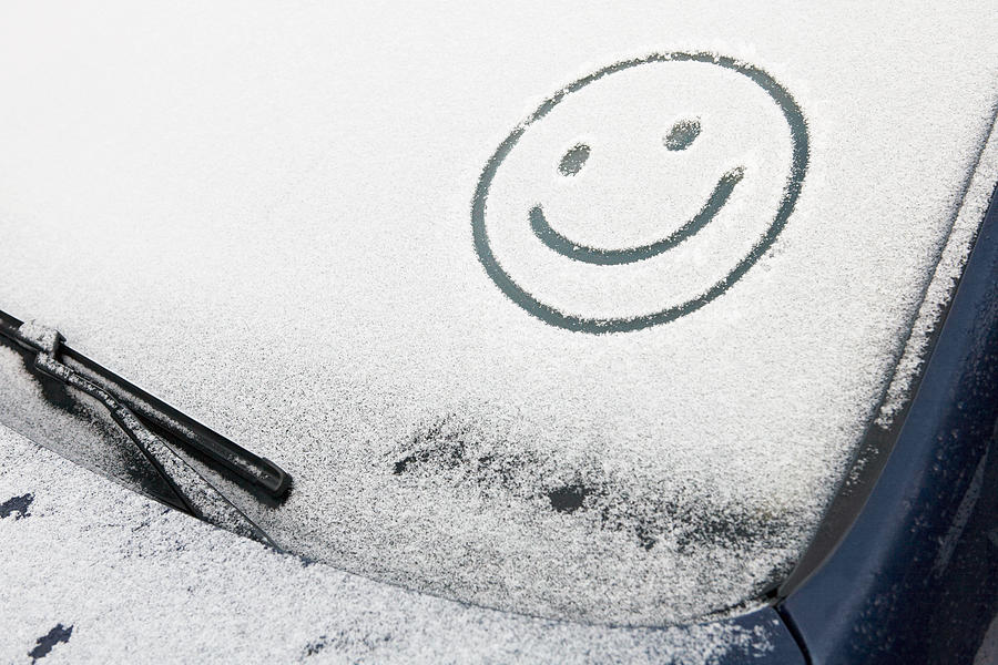 Smiley face in snow on car Photograph by Image Source