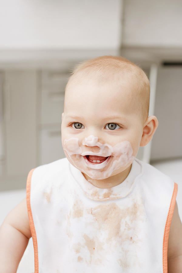 Smiling baby with food covering face and shirt Photograph by Chris Ryan