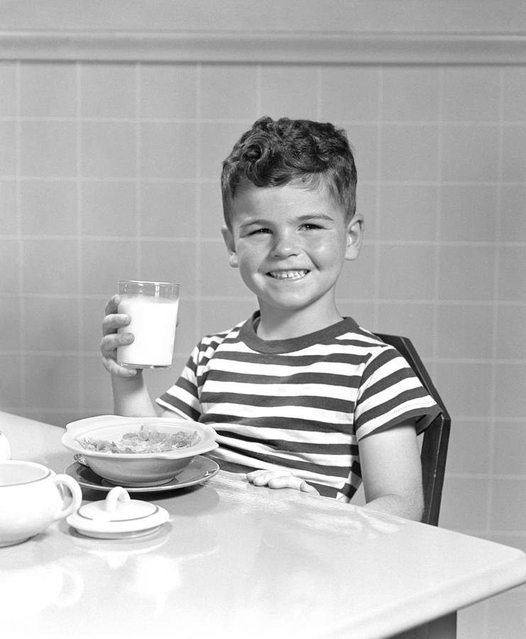 Smiling Boy In Striped T-Shirt Sitting At Table With Bowl Of Cereal & Glass Of Milk In Hand. Photograph by H. Armstrong Roberts