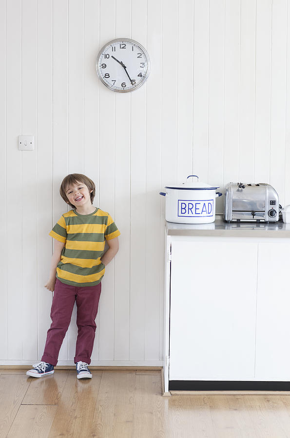 Smiling boy standing in kitchen Photograph by Compassionate Eye Foundation/Natasha Alipour Faridani