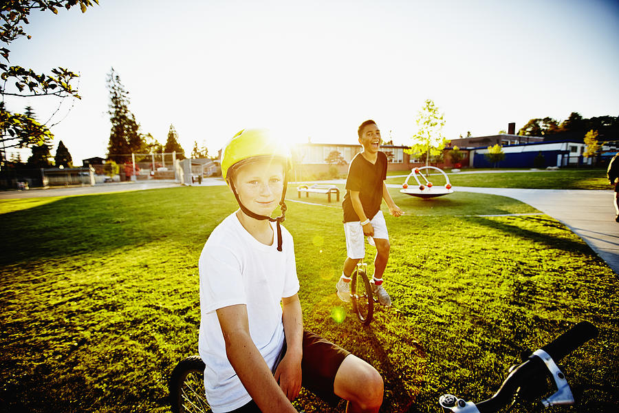 Smiling boys on bicycle and unicycle on field Photograph by Thomas Barwick