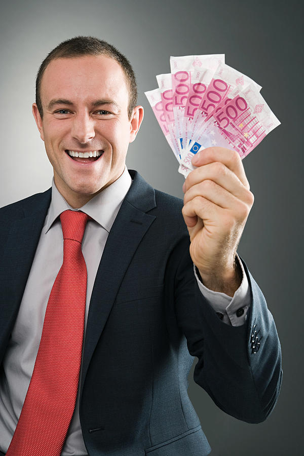 Smiling businessman with bank notes Photograph by Image Source