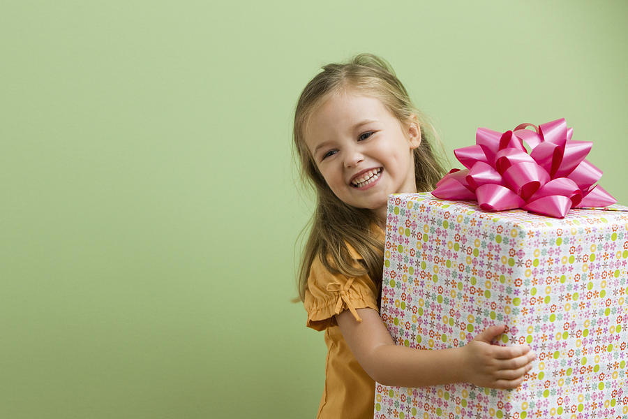 Smiling Caucasian girl holding birthday gift Photograph by Jose Luis Pelaez Inc