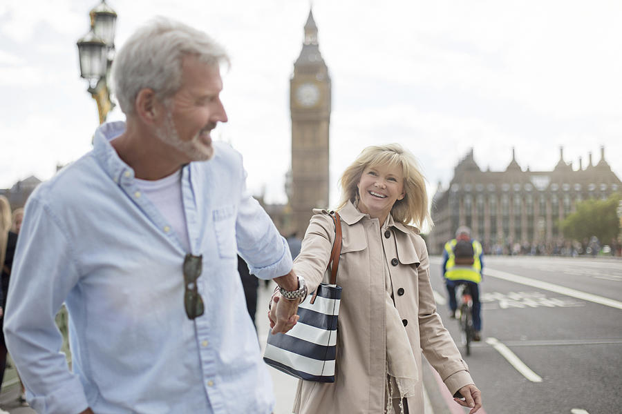 Smiling couple walking on Westminster Bridge Photograph by Xavierarnau