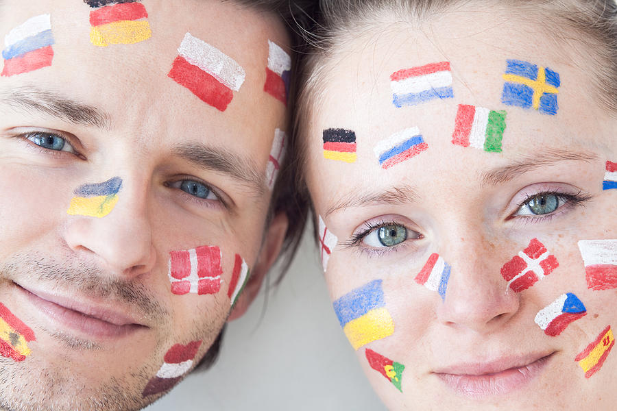 Smiling couple with flag paintings Photograph by Guido Mieth