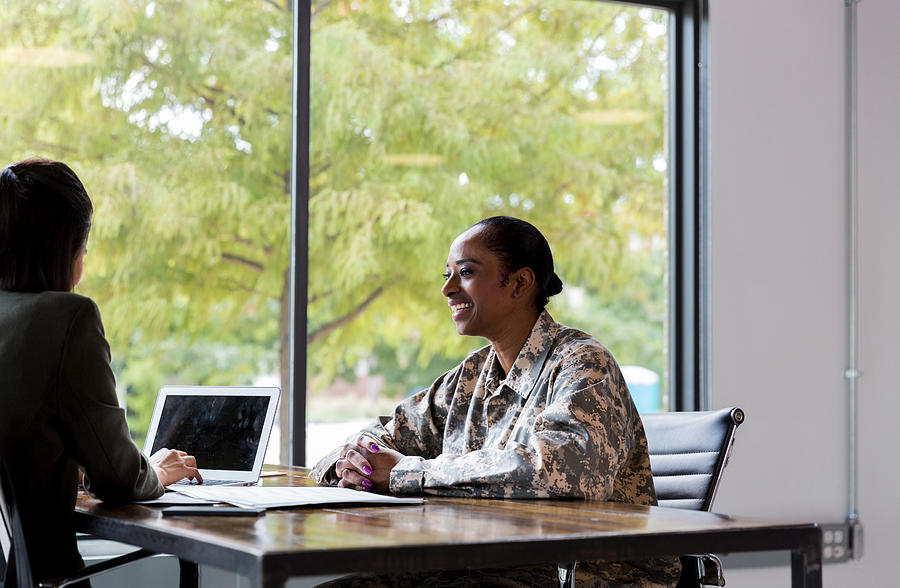 Smiling female veteran talks with financial advisor Photograph by SDI Productions