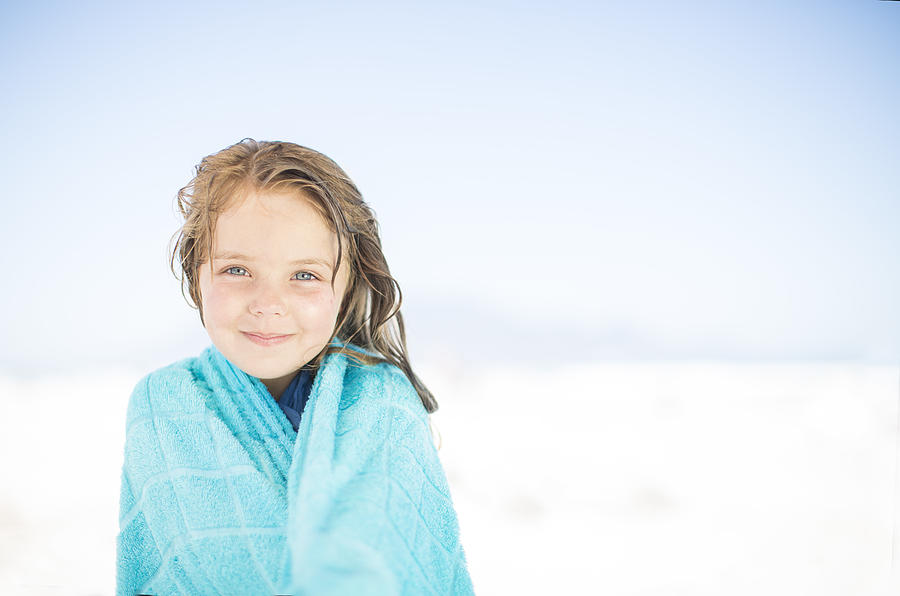 Smiling girl on beach wrapped in a towel Photograph by Westend61