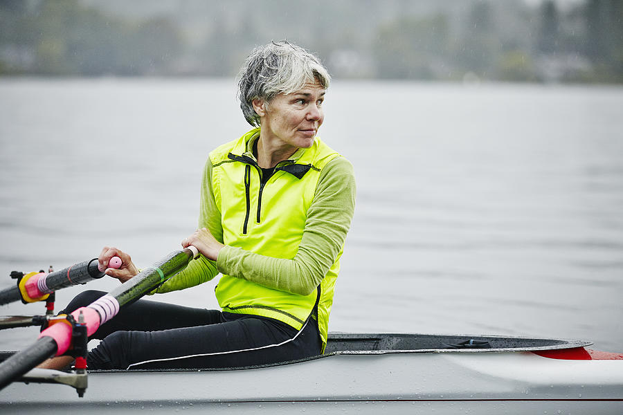 Smiling mature female rower looking over shoulder Photograph by Thomas Barwick