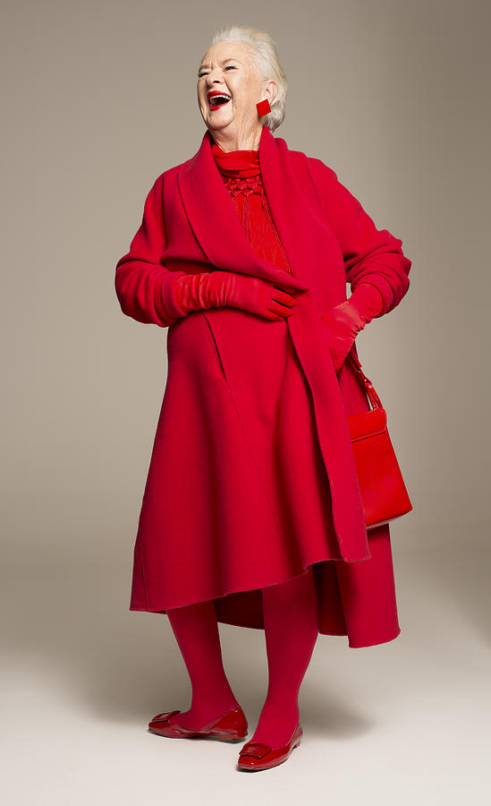 Smiling senior woman wearing red coat Photograph by Compassionate Eye Foundation
