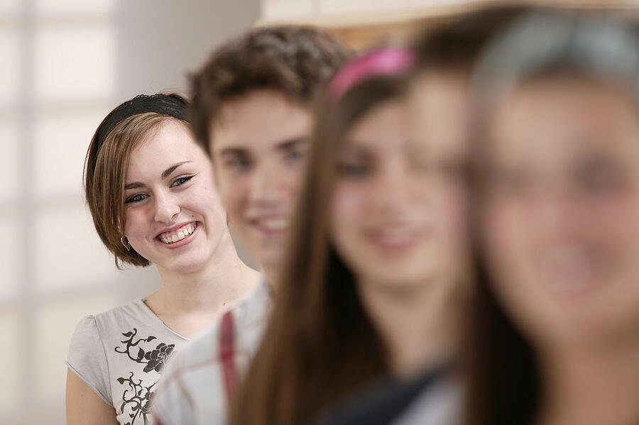 Smiling teenage girl with friends Photograph by Comstock Images