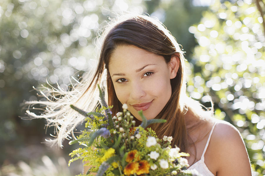 Smiling woman holding bouquet of flowers Photograph by Tom Merton