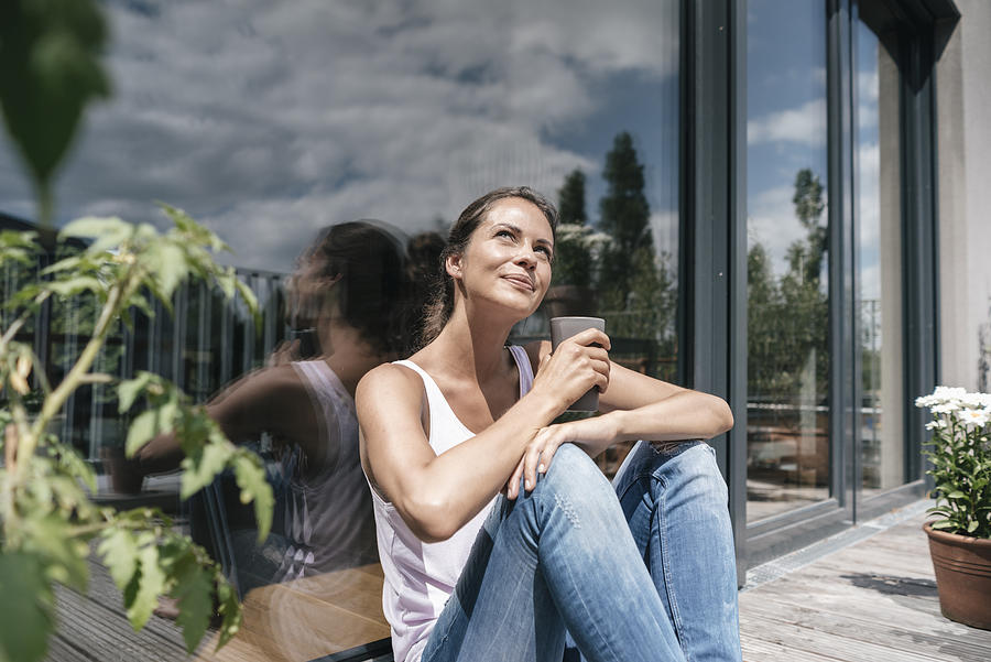 Smiling woman relaxing on balcony Photograph by Westend61