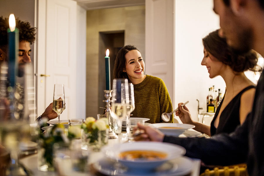 Smiling woman talking with friends while having dinner Photograph by Luis Alvarez