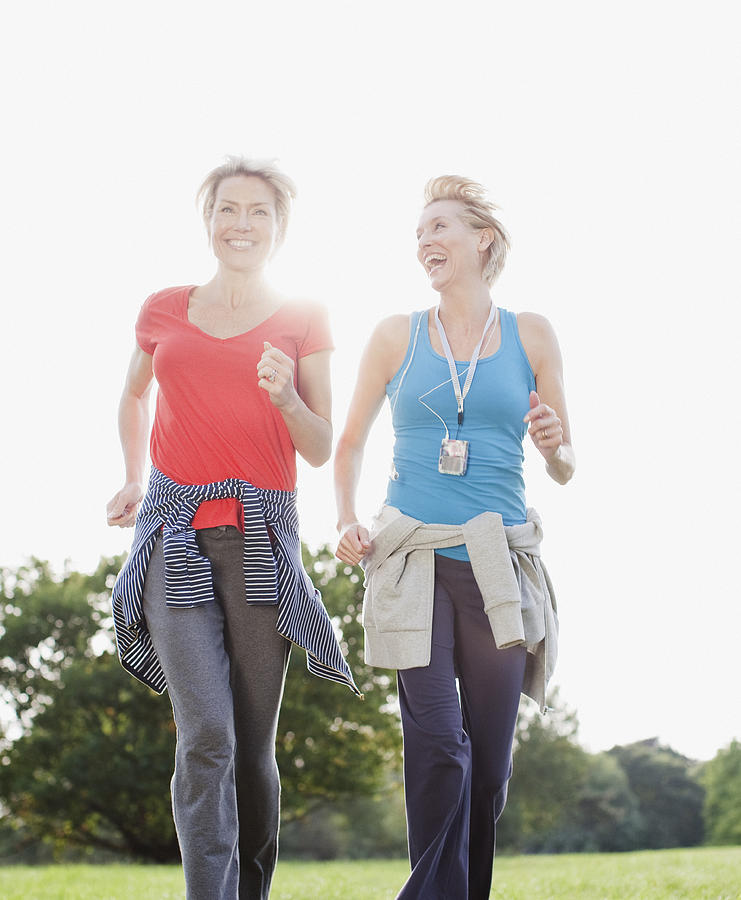 Smiling women jogging together Photograph by Robert Daly