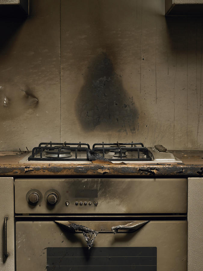 Smoke stained cooker in kitchen after fire Photograph by Michael Blann