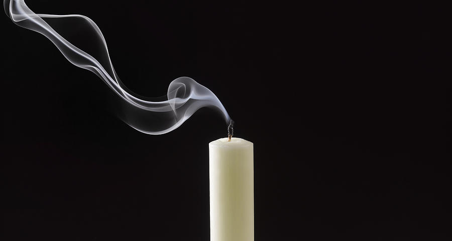 Smoke trailing from extinguished white candle Photograph by Peter Dazeley